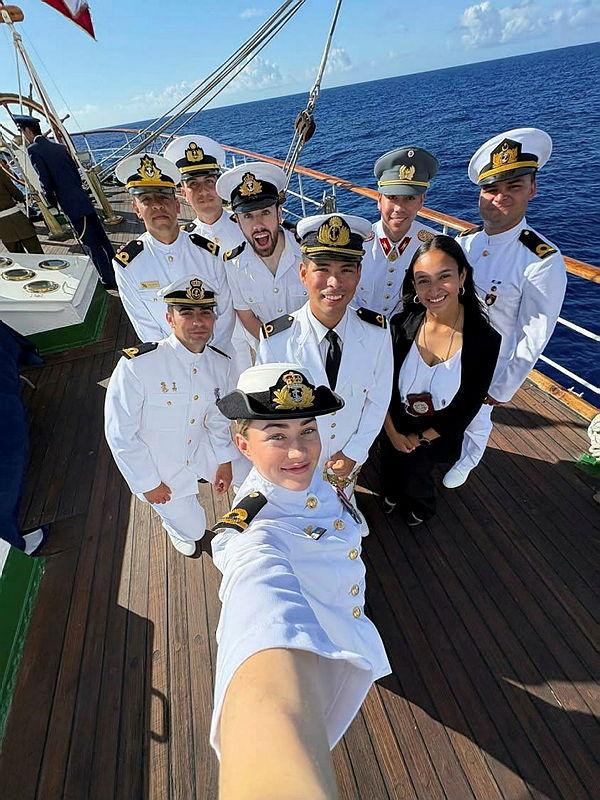 A group of people, most in uniform, pose for a selfie.