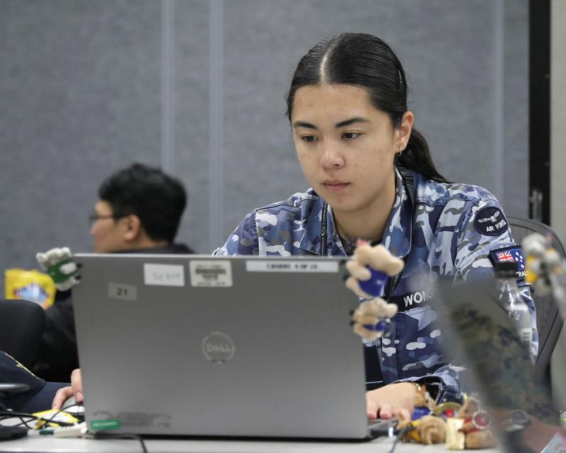 An Australian Air Force woman works on a laptop.