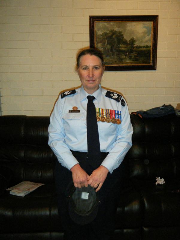 A woman in military uniform wears six military medals.