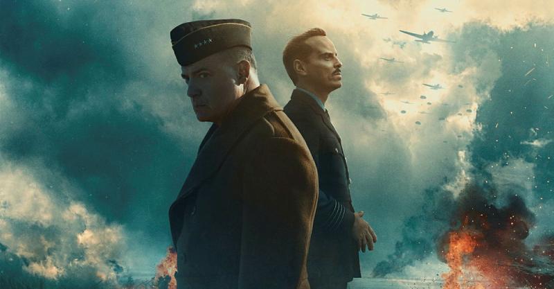 Two military men standing against a backdrop of dark storm clouds and planes in the distance.