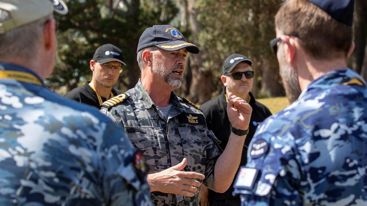 A man uses his hands to give instructions to a group.