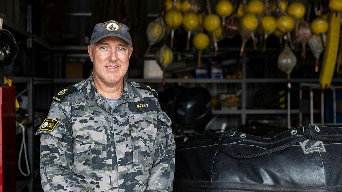 A sailor stands in a warehouse.