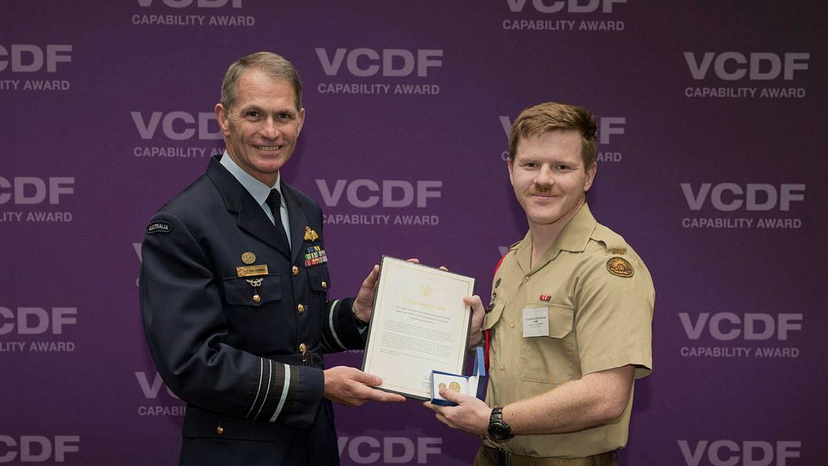 Two men holding up a certificate between them.