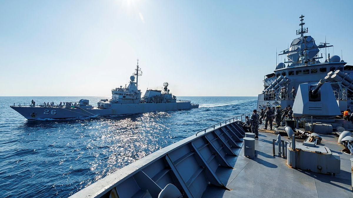 Two ships side by side in the open ocean.