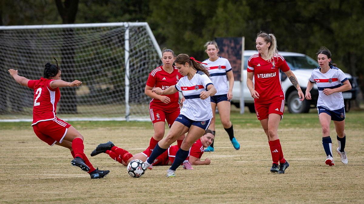 Australian Army Officer Cadet Johanna Whittle kicking the ball during a game against the British Royal Electrical and Mechanical Engineers football team in Canberra 2026.