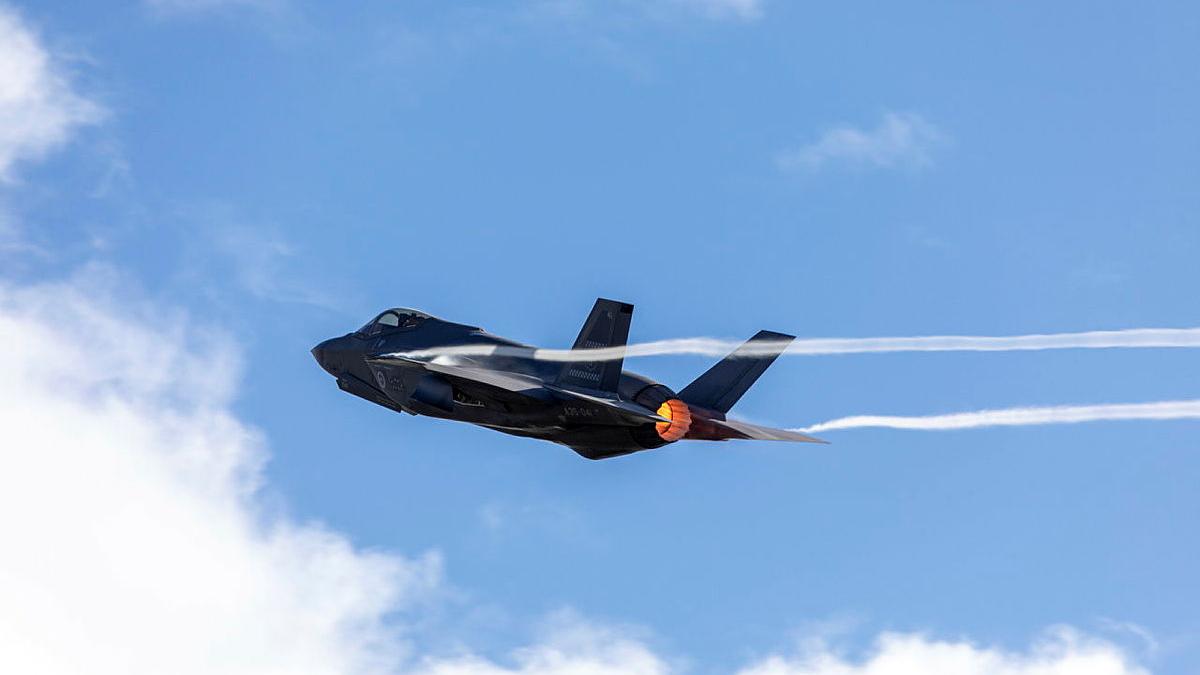 A black jet flies through the air.