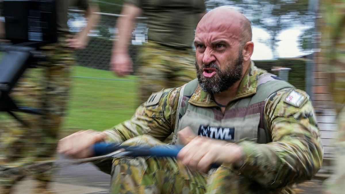 A military member uses a rowing machine.