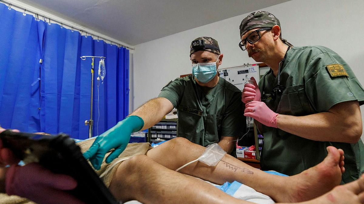 Australian Army Anaesthetist  Major Ashley St John (left) and Major Joseph Dawson (right) administers a peripheral nerve block ahead of performing minor surgery on a member of Operation Render Safe 26, at the Role 2 in Kokopo, Papua New Guinea.