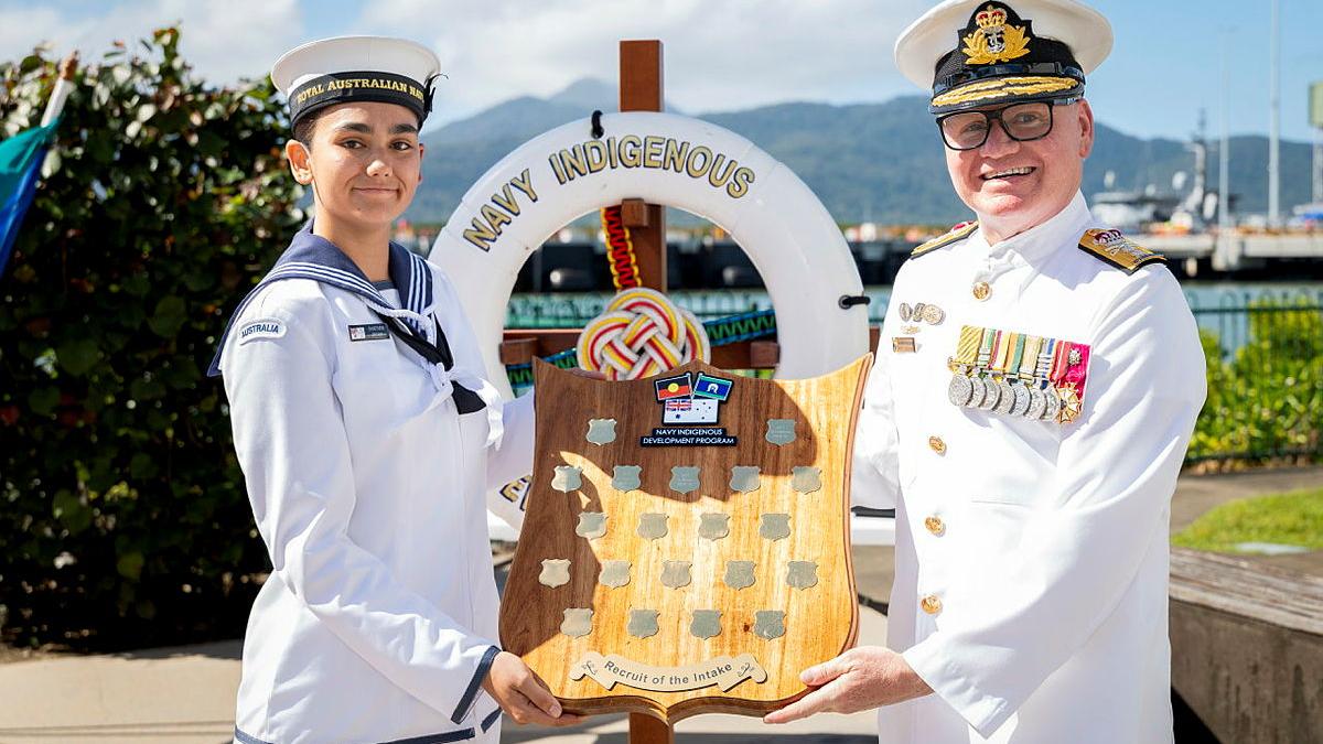Two people hold a plaque. 