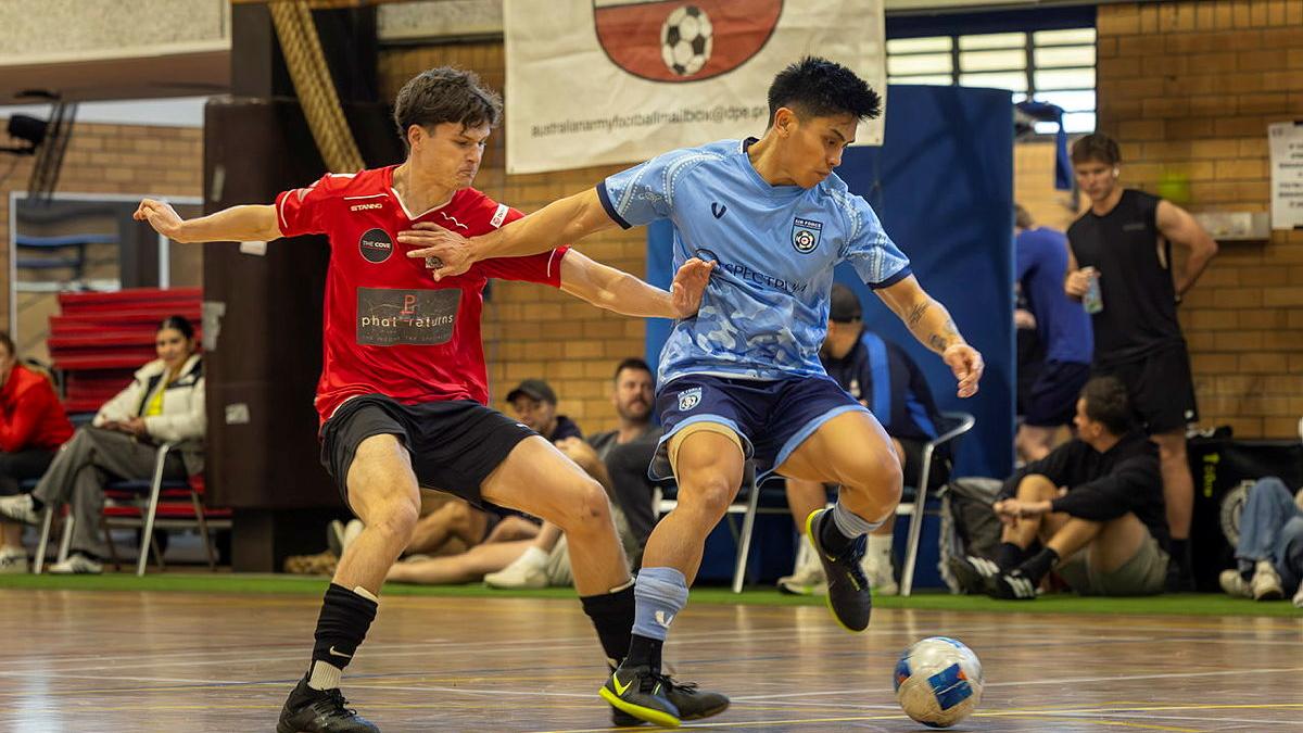 Two players compete in a game of futsal.