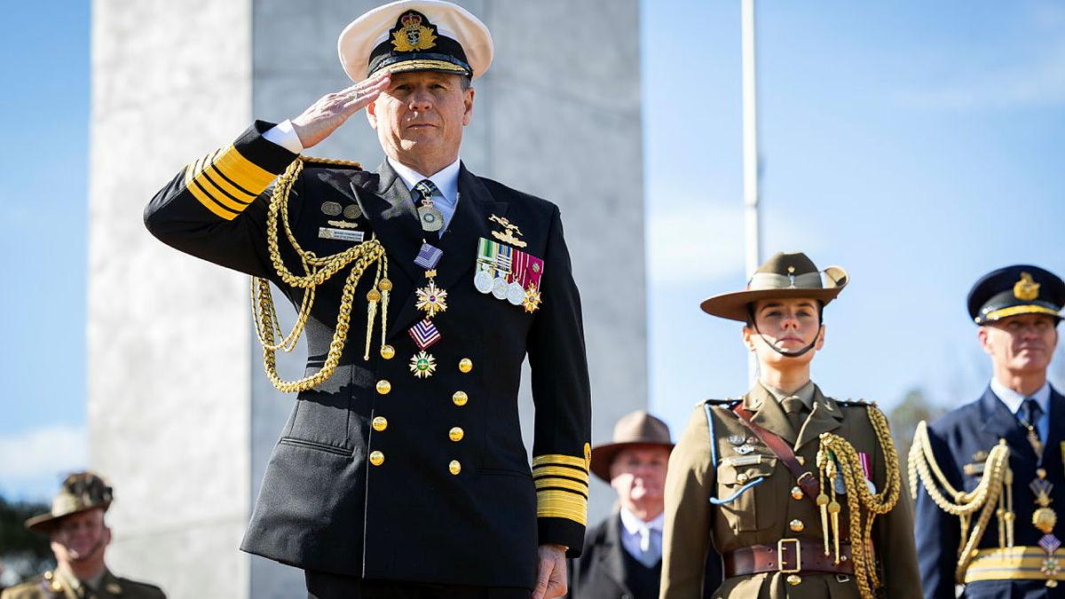 A man stands and salutes.