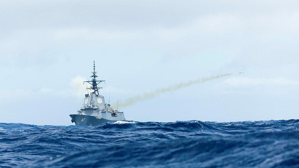 A missile fires from a ship at sea.