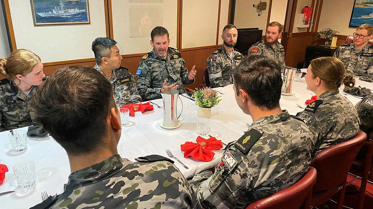 Sailors sit around a dining table.