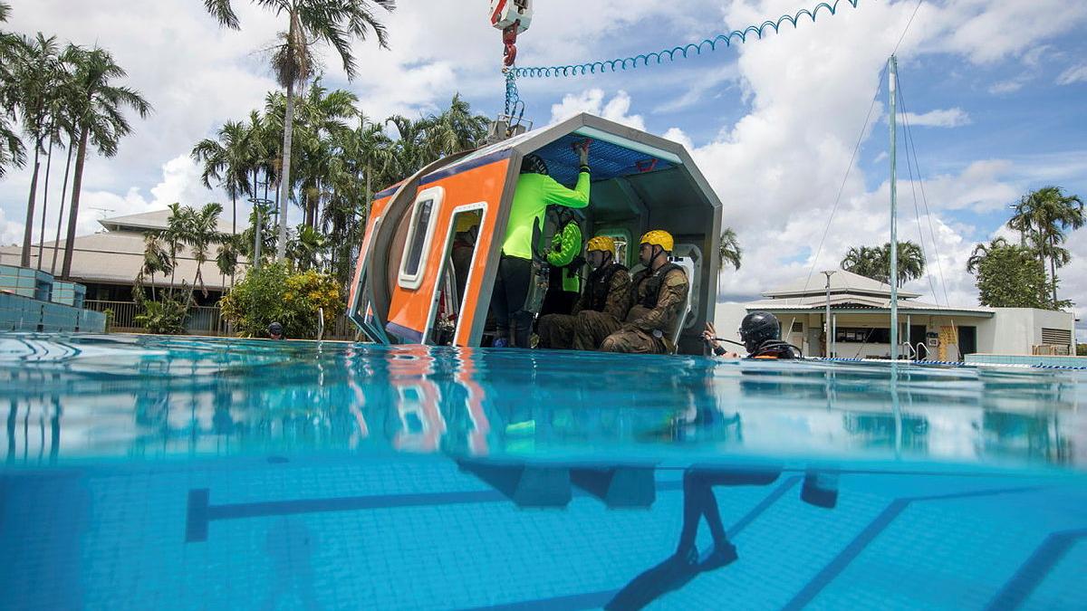 Soldiers are seen inside a training capsule in a swimming pool.