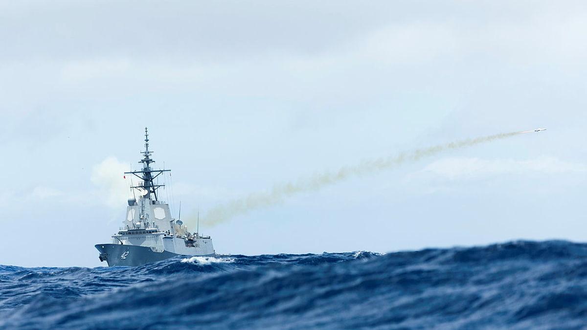 A missile is shot from a ship at sea.