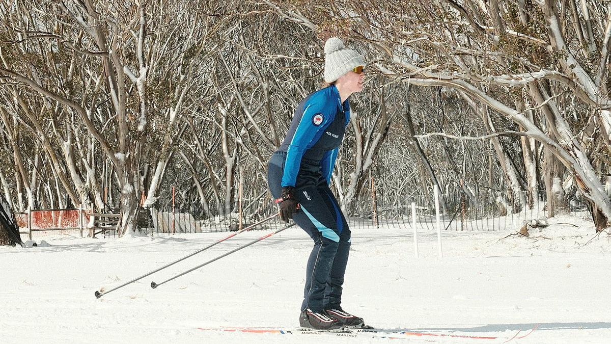 An Air Force woman skis on a flat run.