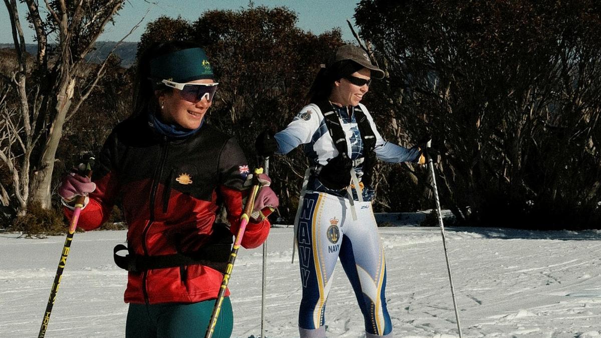 Two women in skis in the snow.