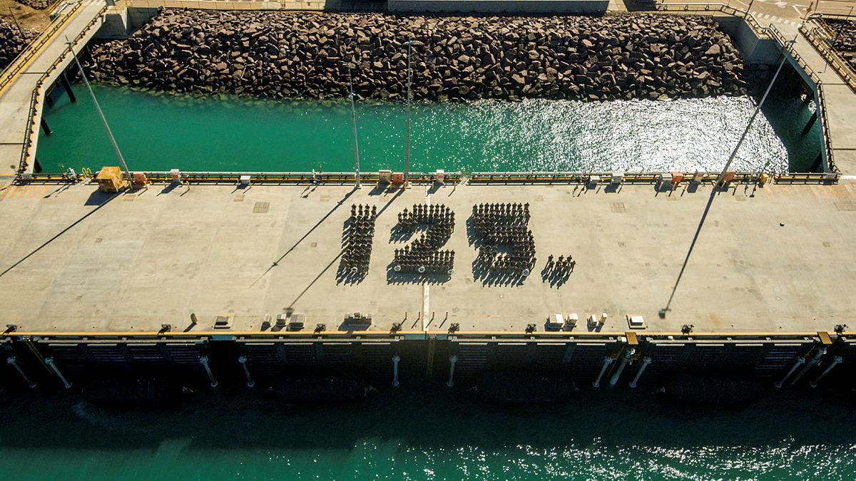 People form the number 125 on a wharf.