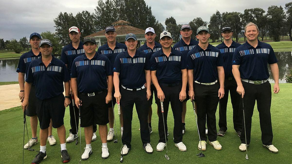 A team of Air Force golfers hold their clubs, smile and face the camera.