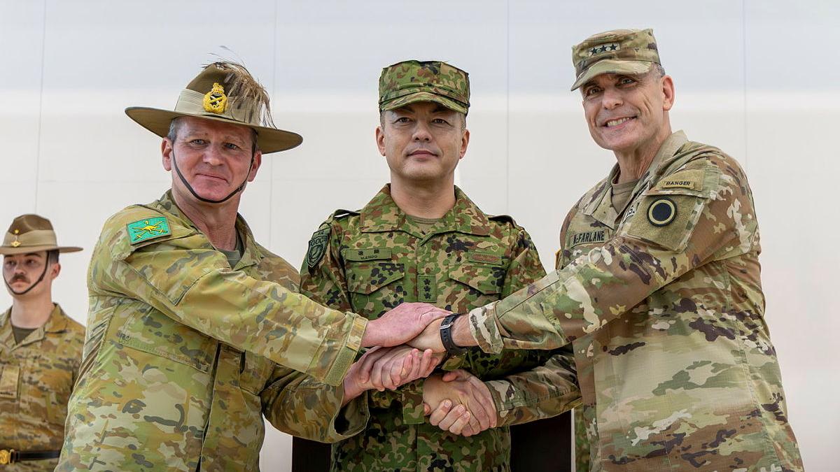 Three military men all hold hands.