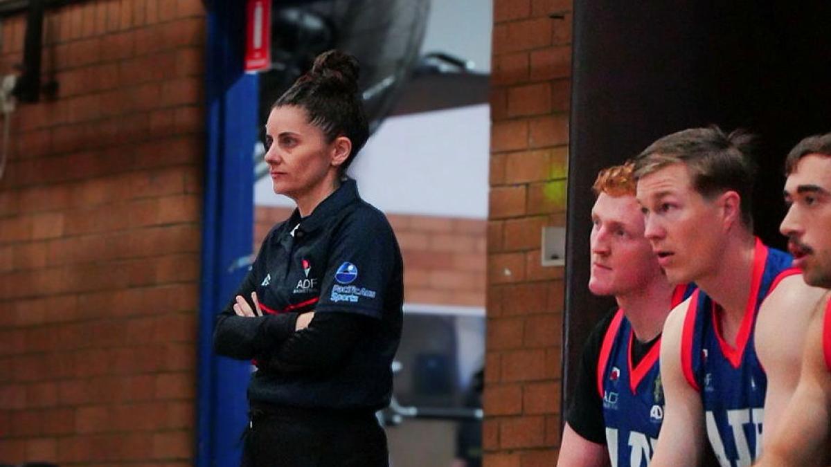 An Australian Defence Force member coaches her team from the sidelines. 
