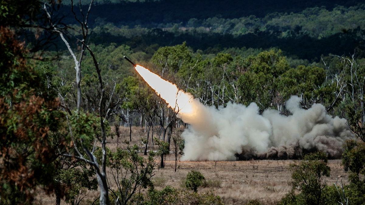 A missile shoots up from the ground in bush land.