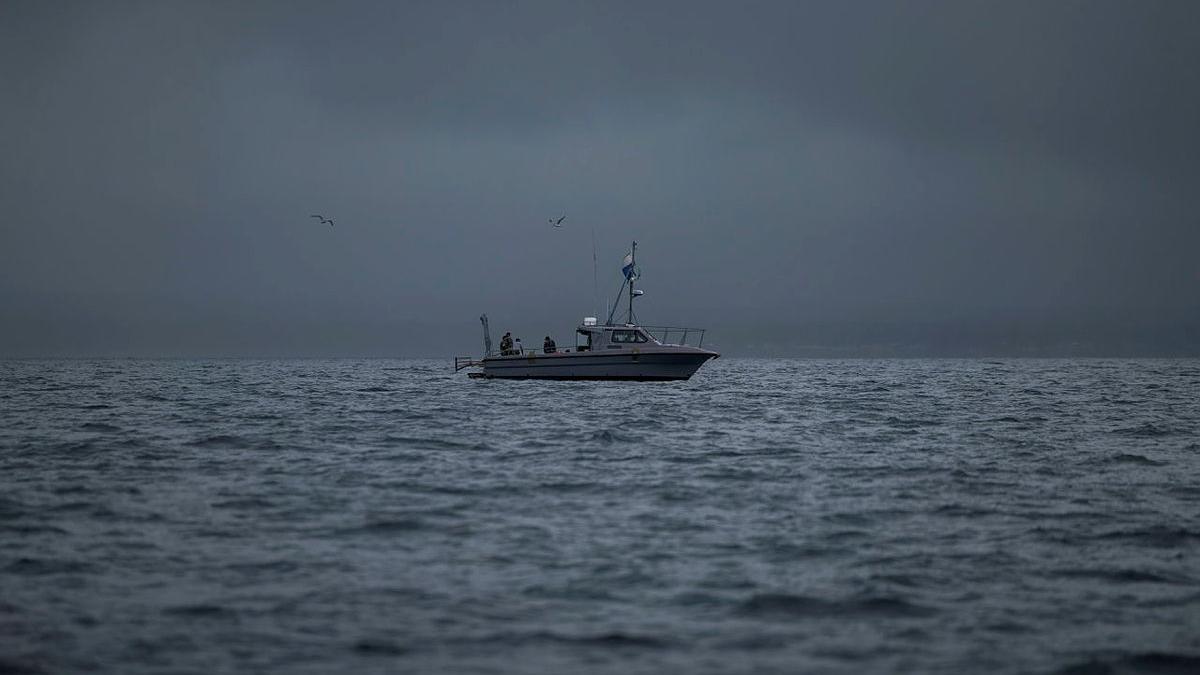 A small boat at sea on a stormy day.