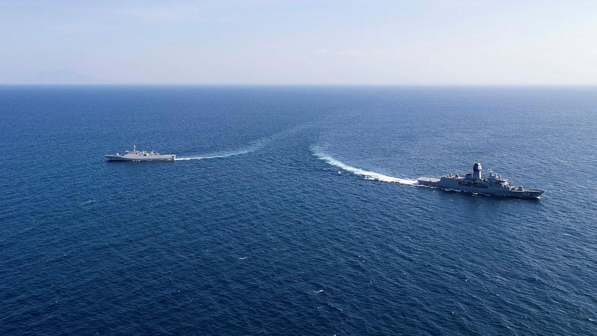 Two ships sail in opposite directions in the ocean.