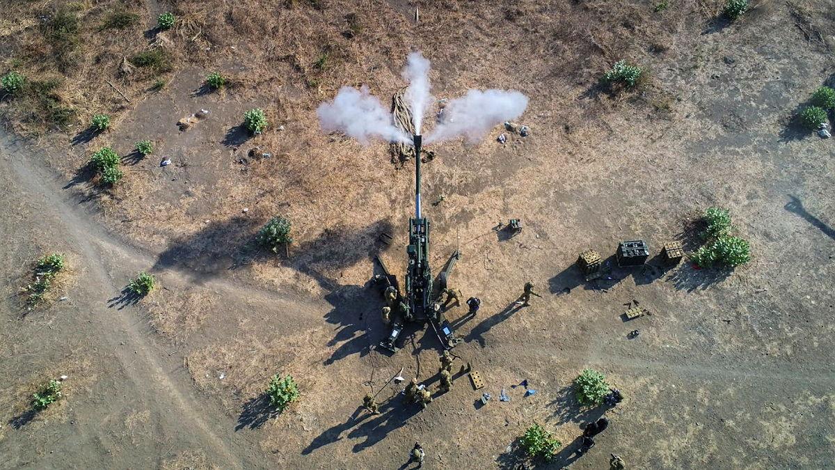 Aerial view of a large Army gun being fired.