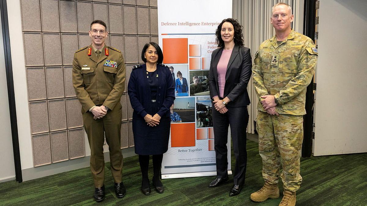 Three military members (two men and one woman) and a civilian woman.
